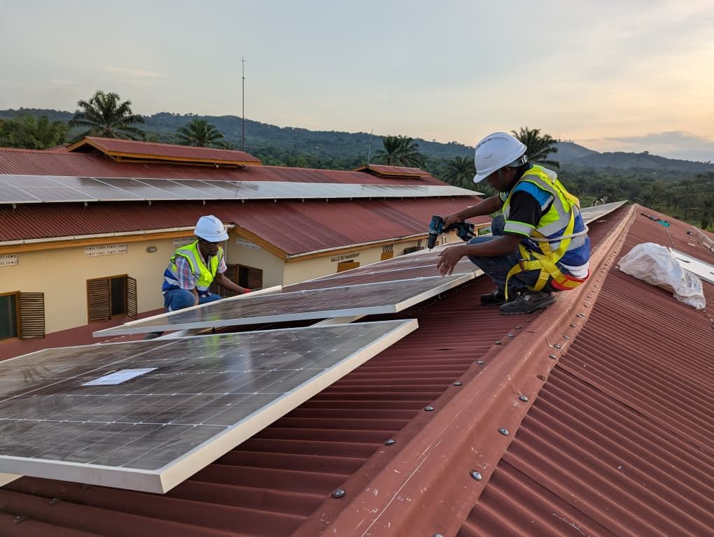 Techniciens GEERS posant des panneaux solaires sur une toiture en tôle